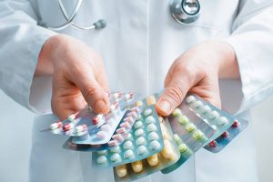 Hand of doctors holding many different pills